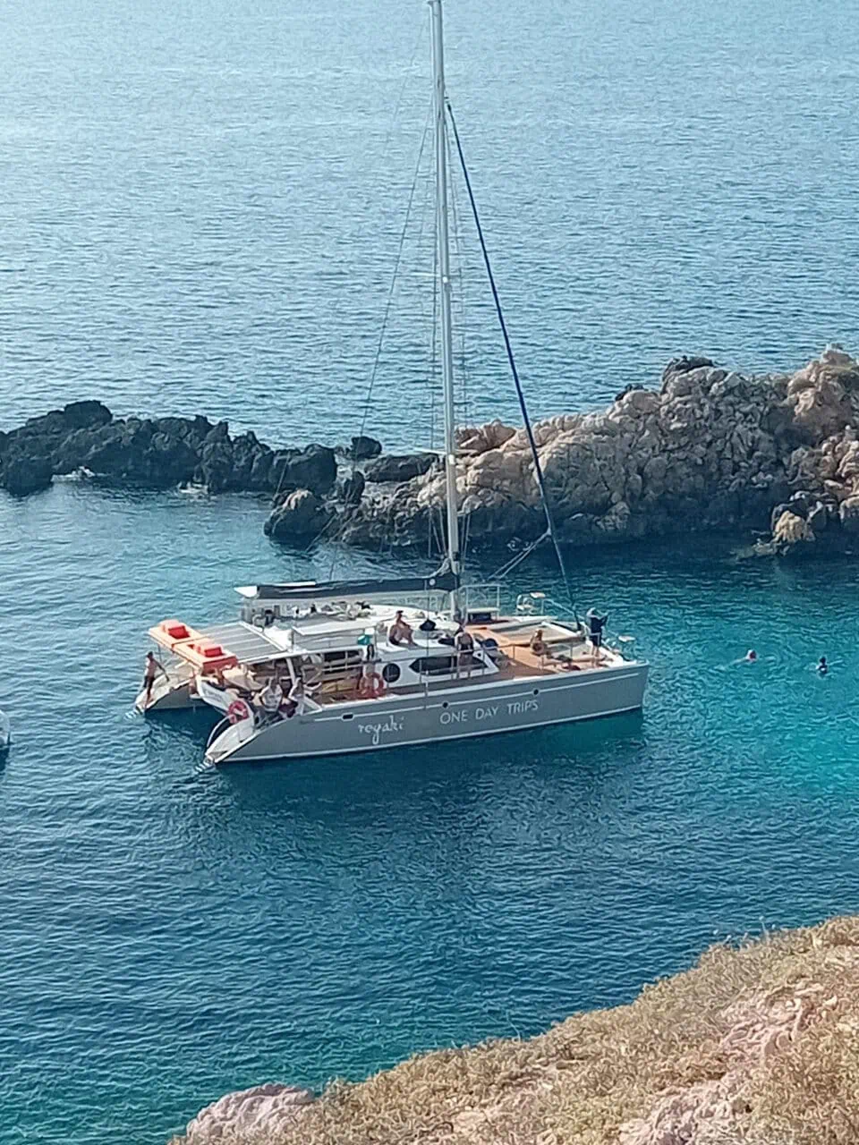 Photo of the Regaki Catamaran with passengers enjoying the sea on a sunny day, showcasing a memorable trip