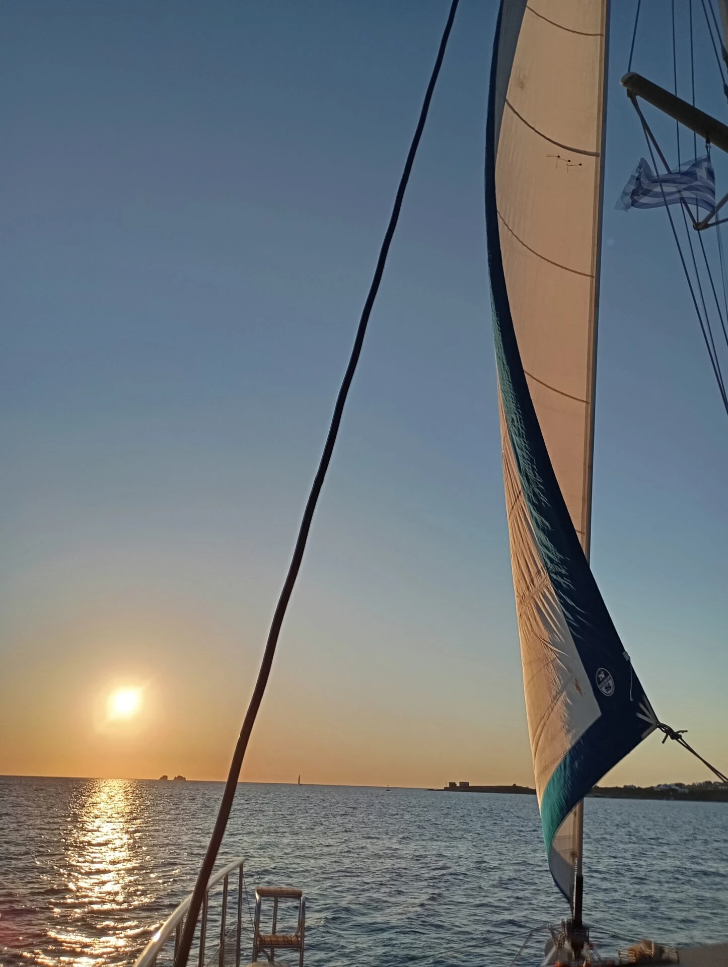 The sunset beside the sail of the Regaki Catamaran
